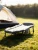 freepik__foldable-camping-bed-set-on-grass-next-to-an-open-__52892.webp